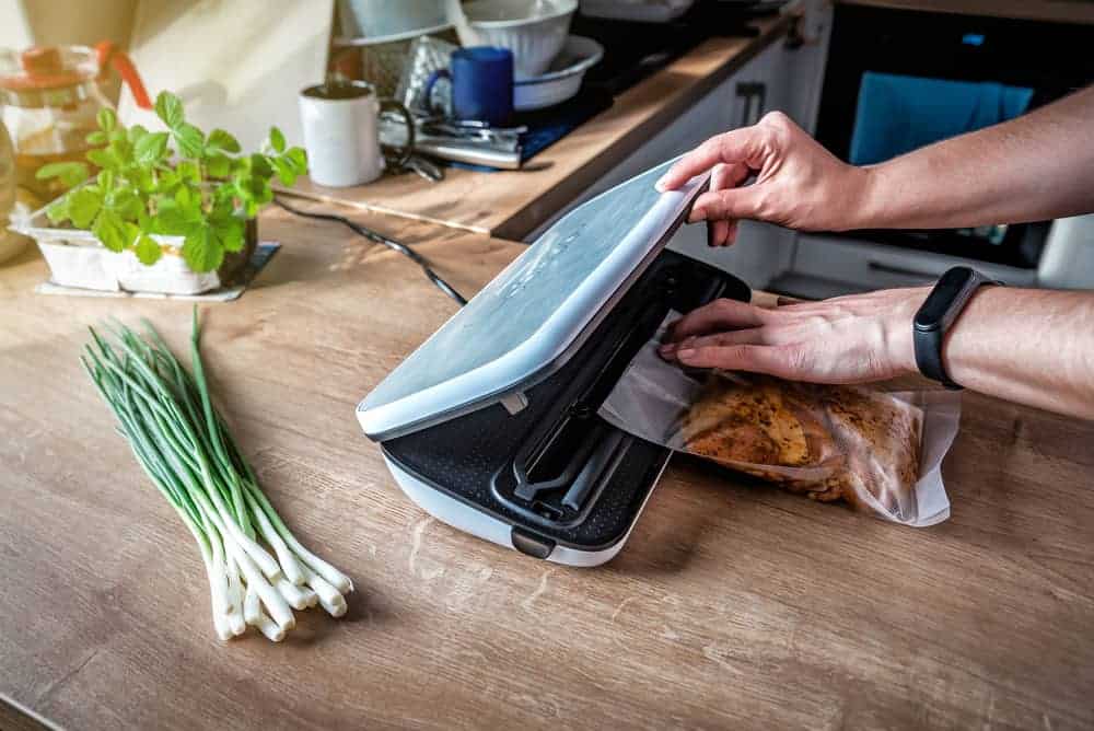 Woman Inserting a Vacuum Bag into the Machine