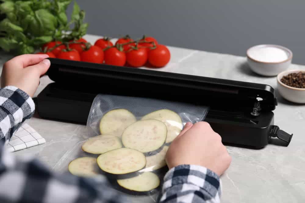 Woman Vacuum Sealing Eggplant Slices